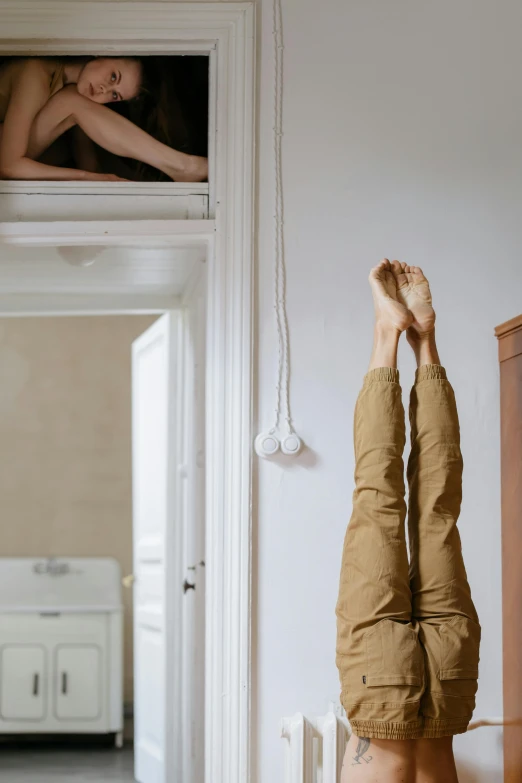 a woman upside down on her bed next to a mirror