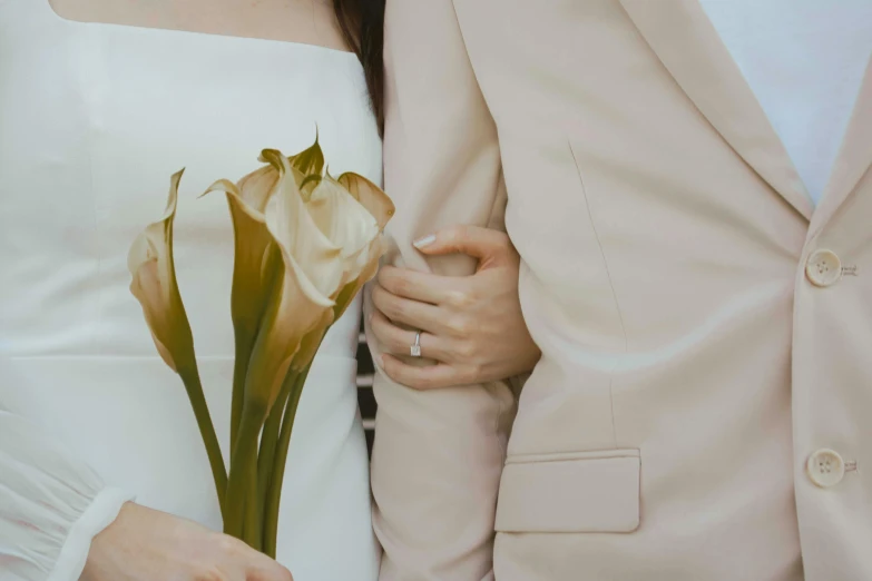 two people in formal clothing with one holding a flower