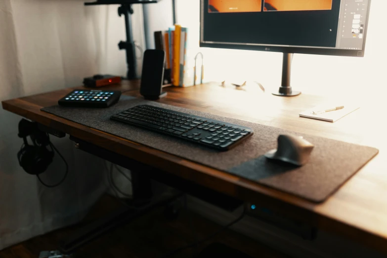 a computer on a wooden desk in front of a monitor