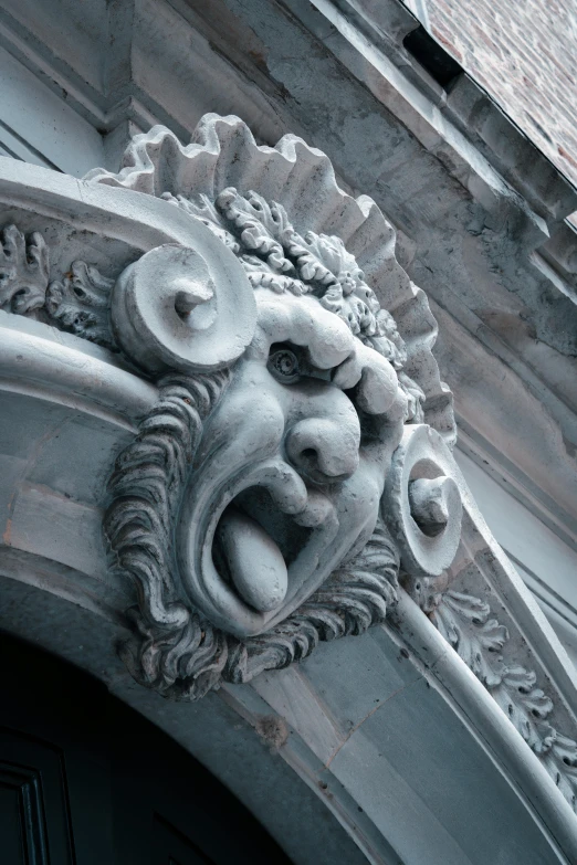 an elaborate gargoyle above a doorway on a building