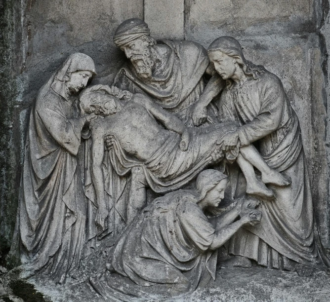 a stone sculpture depicting a religious scene with people