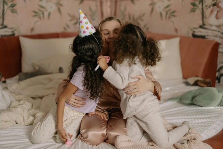 two girls hug each other on the bed