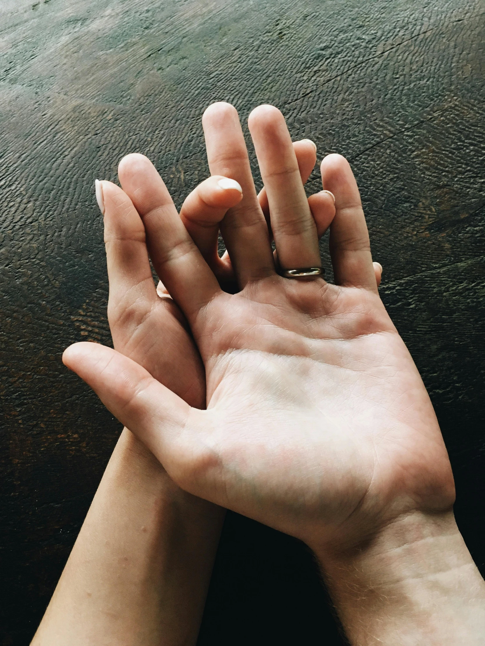 two people's hands in the air and holding each other