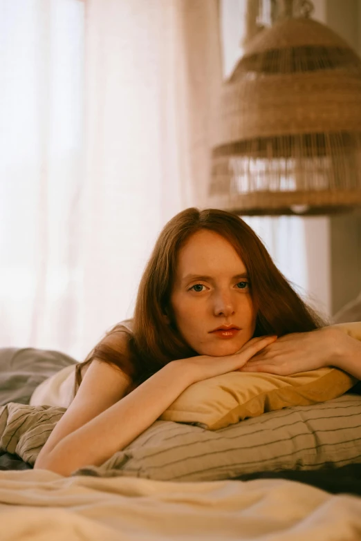 woman laying on bed with arm under pillow