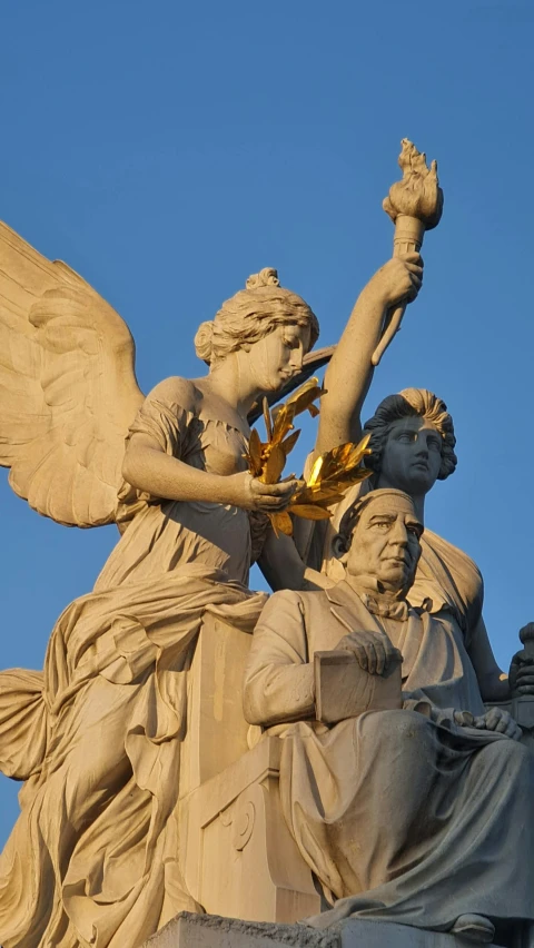 a statue of angel statues with golden leaves on their hands