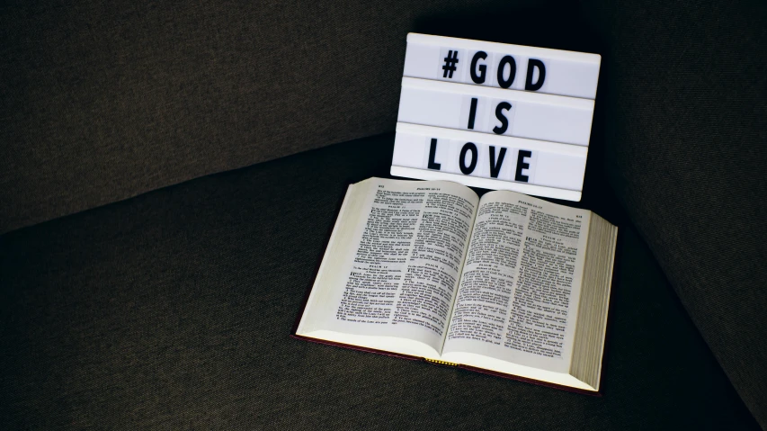 a small book is opened and displayed with lit bricks saying god is love