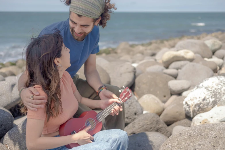 there is a man and woman that are playing the guitar