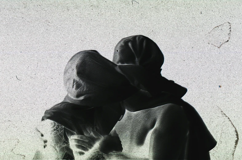 two women in hoodeds sitting on the ground next to each other