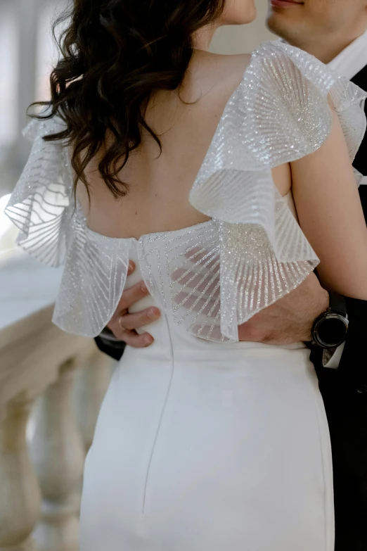 an elegant bride and groom emcing with the bride wearing a beaded white dress