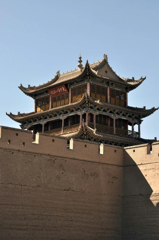 a building is on top of a wall and some sky is in the background