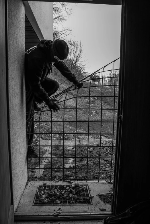 a person in an old house standing next to a gate