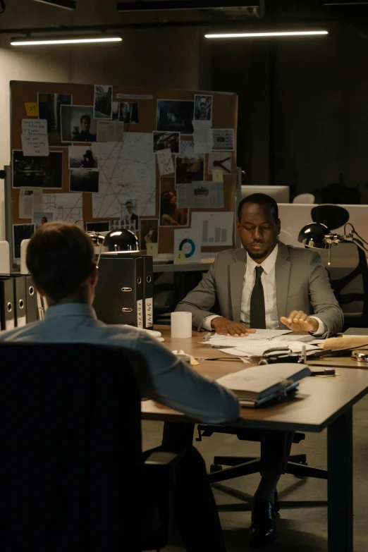 two men in business suits sitting at a table together