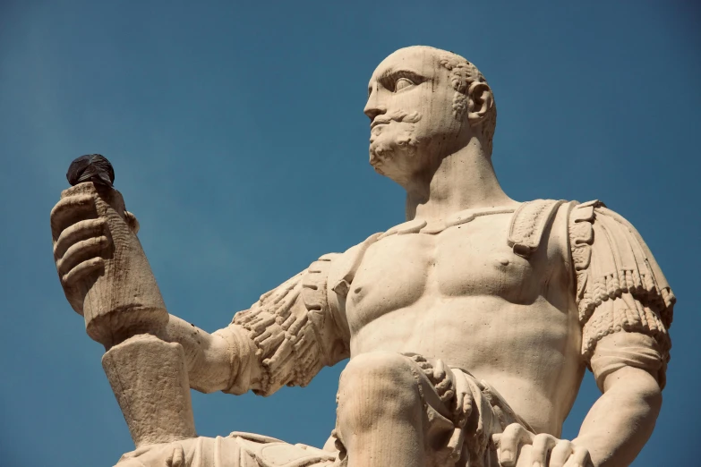 statue of an seated greek man holding his right hand up to his right and a bird on his left arm