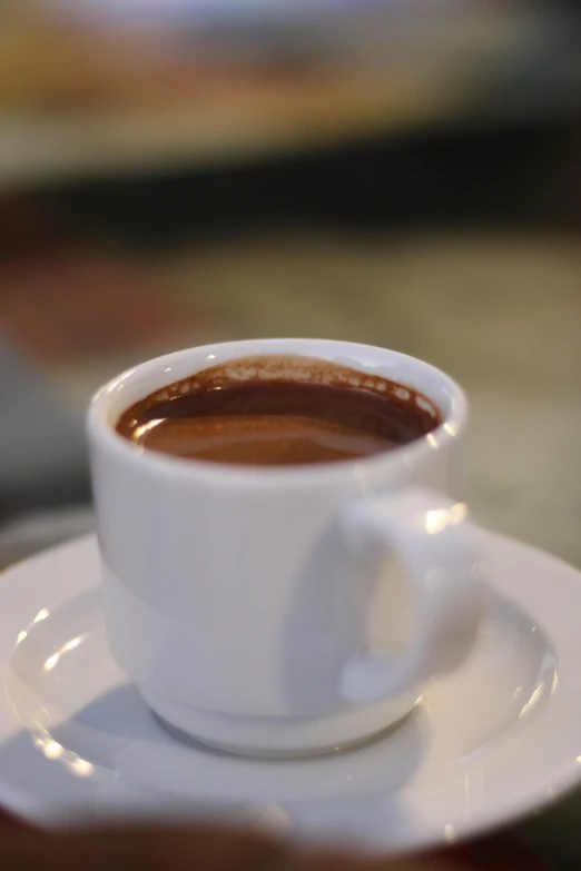 a cup of coffee on a saucer on a table