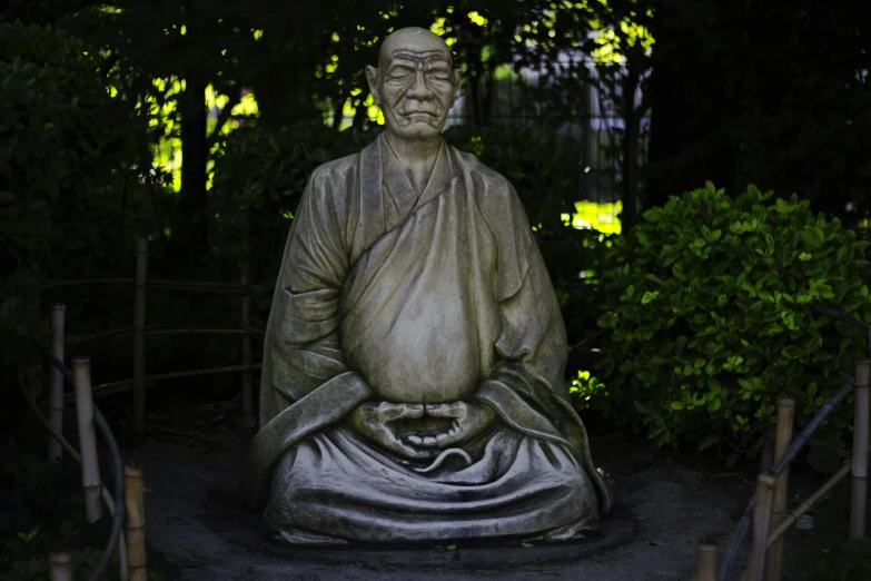 an asian statue in a small garden setting