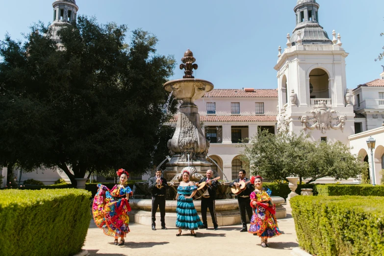 a group of people with mexican outfits on in front of an ornamental building