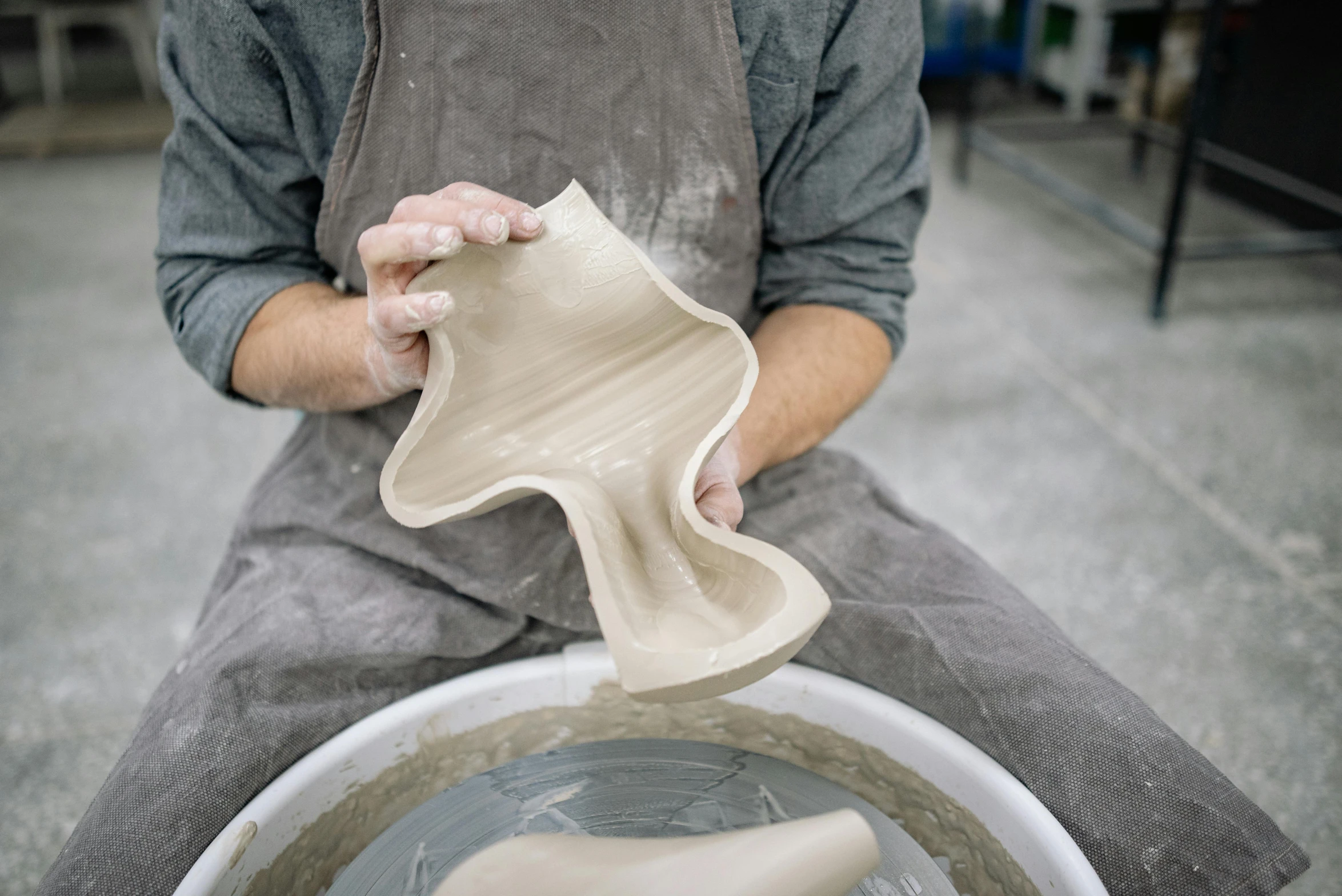 a man is working with pottery on his workbench