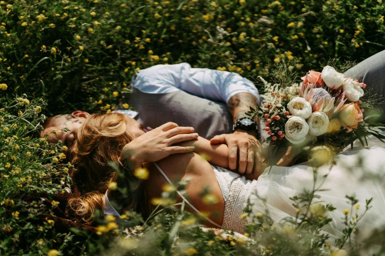 a couple cuddling together lying on the grass