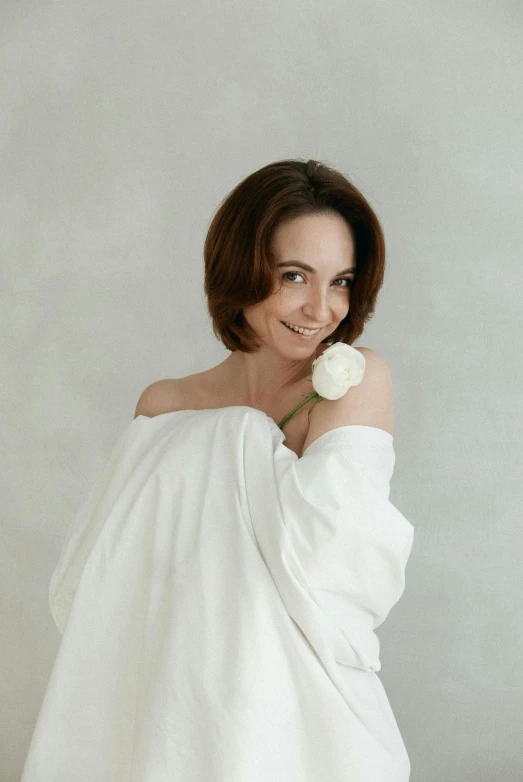 a woman wrapped in a white towel with a flower