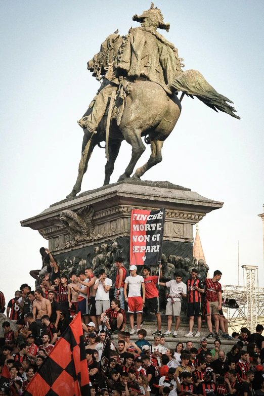 a crowd of people watching and watching the statue