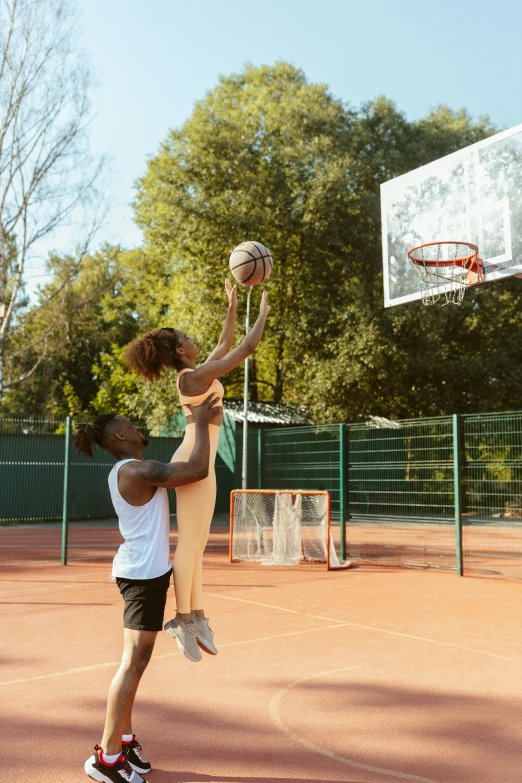 there is an adult and child playing basketball