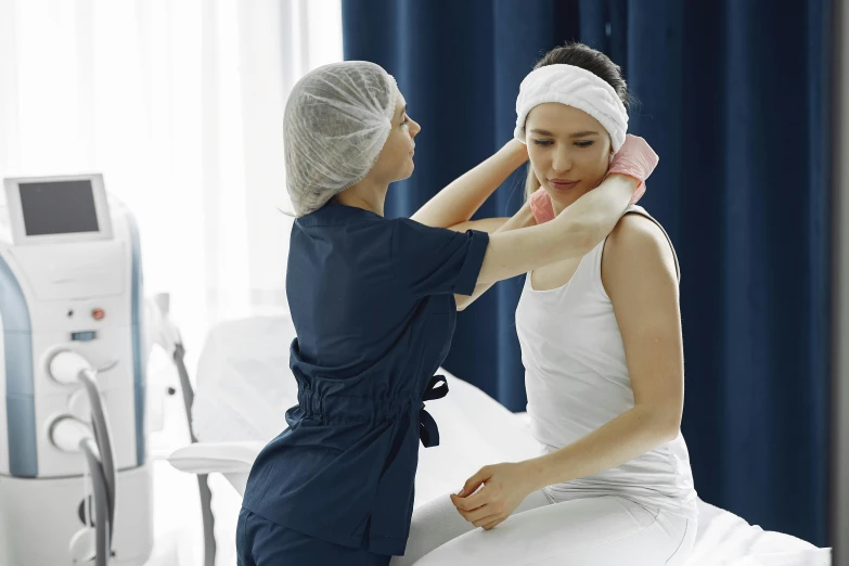 two people at the doctor and one woman wearing a towel on her head