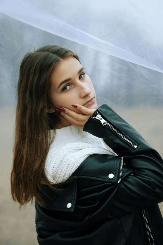 a beautiful young woman holding an umbrella under her head