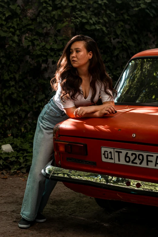 a woman standing on the hood of an old red truck