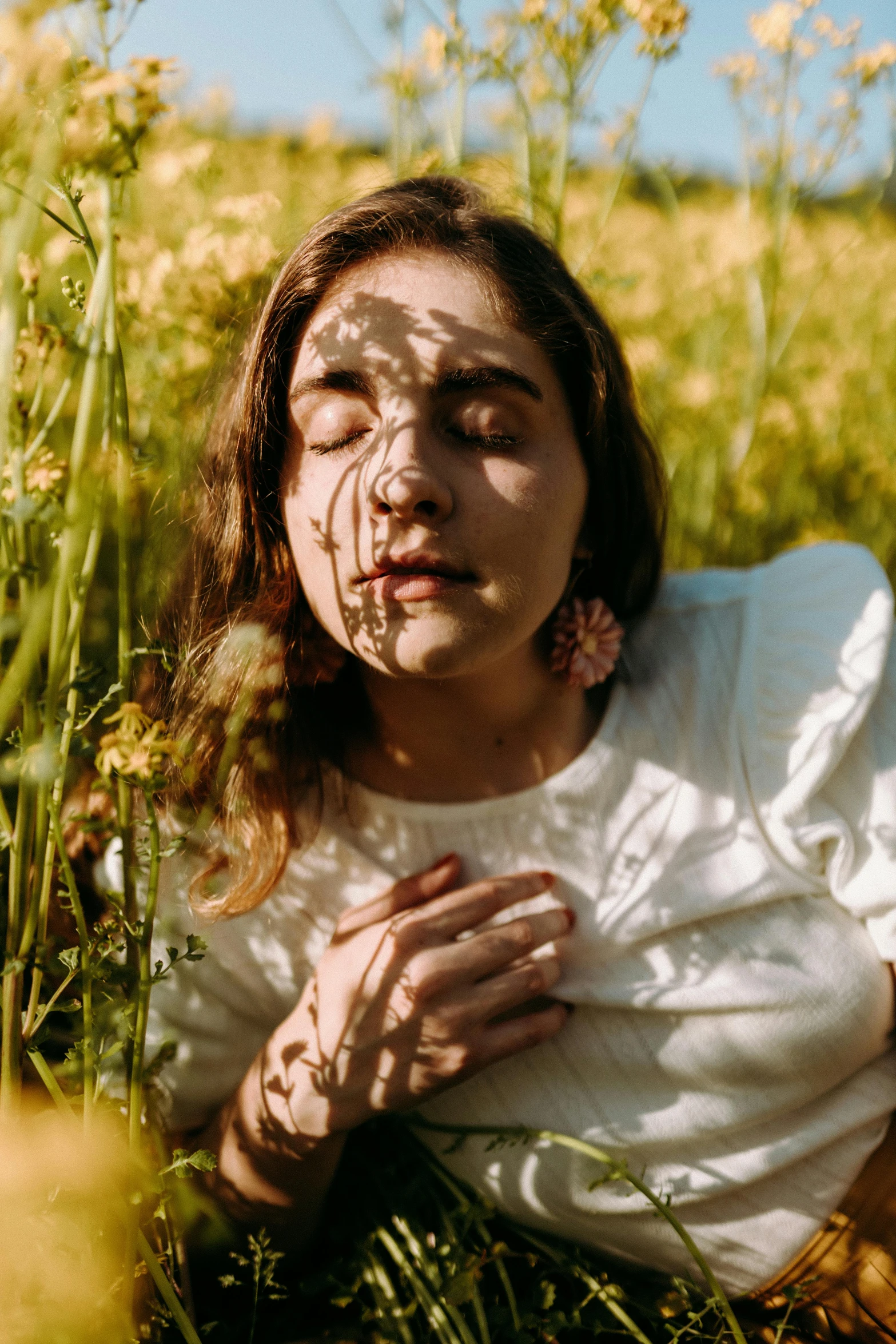 a woman is kneeling in some grass with her eyes open