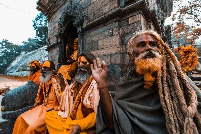 an old man with beards, with other men sitting in front of him