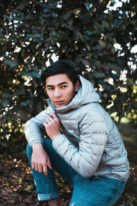 a man sitting under a tree with a scarf around his neck