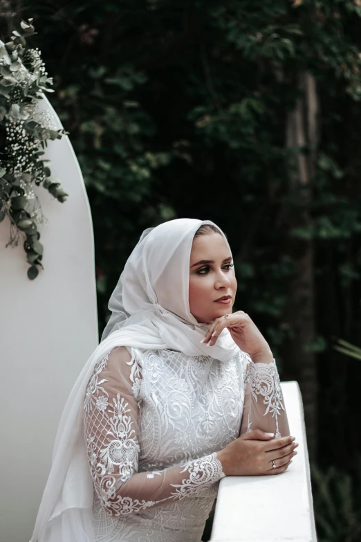 the bride is leaning against a white railing