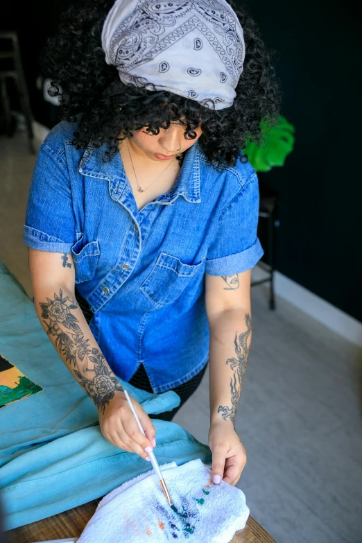 a woman with black curly hair is using a brush