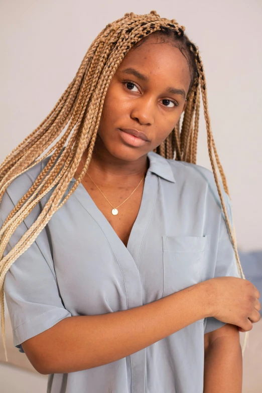 a girl with blond hair standing near a wall