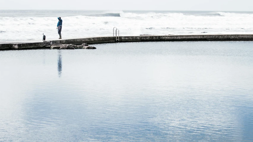 an image of man and his dog at the waters edge