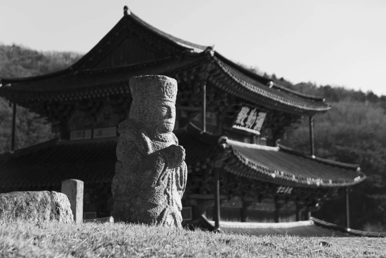 an asian building that has a carved statue in front of it