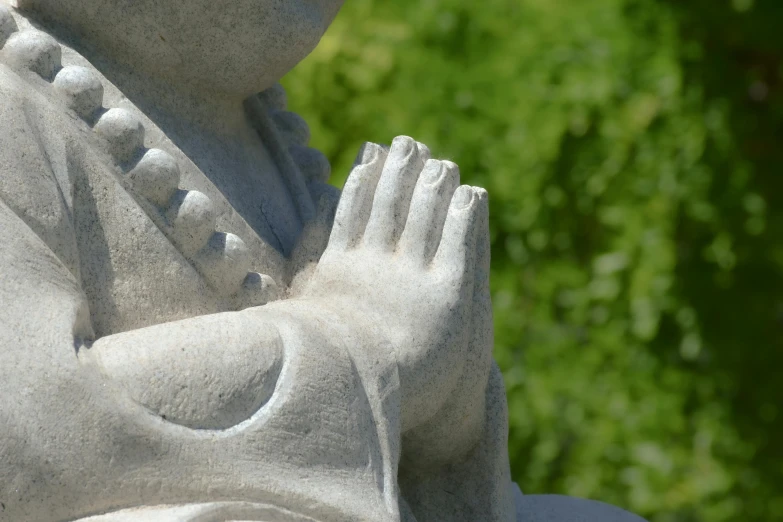 a statue holds her hands out to a praying person