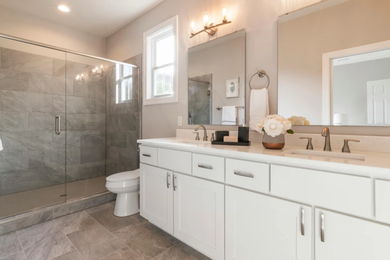 bathroom with large white cabinets, and walk - in shower