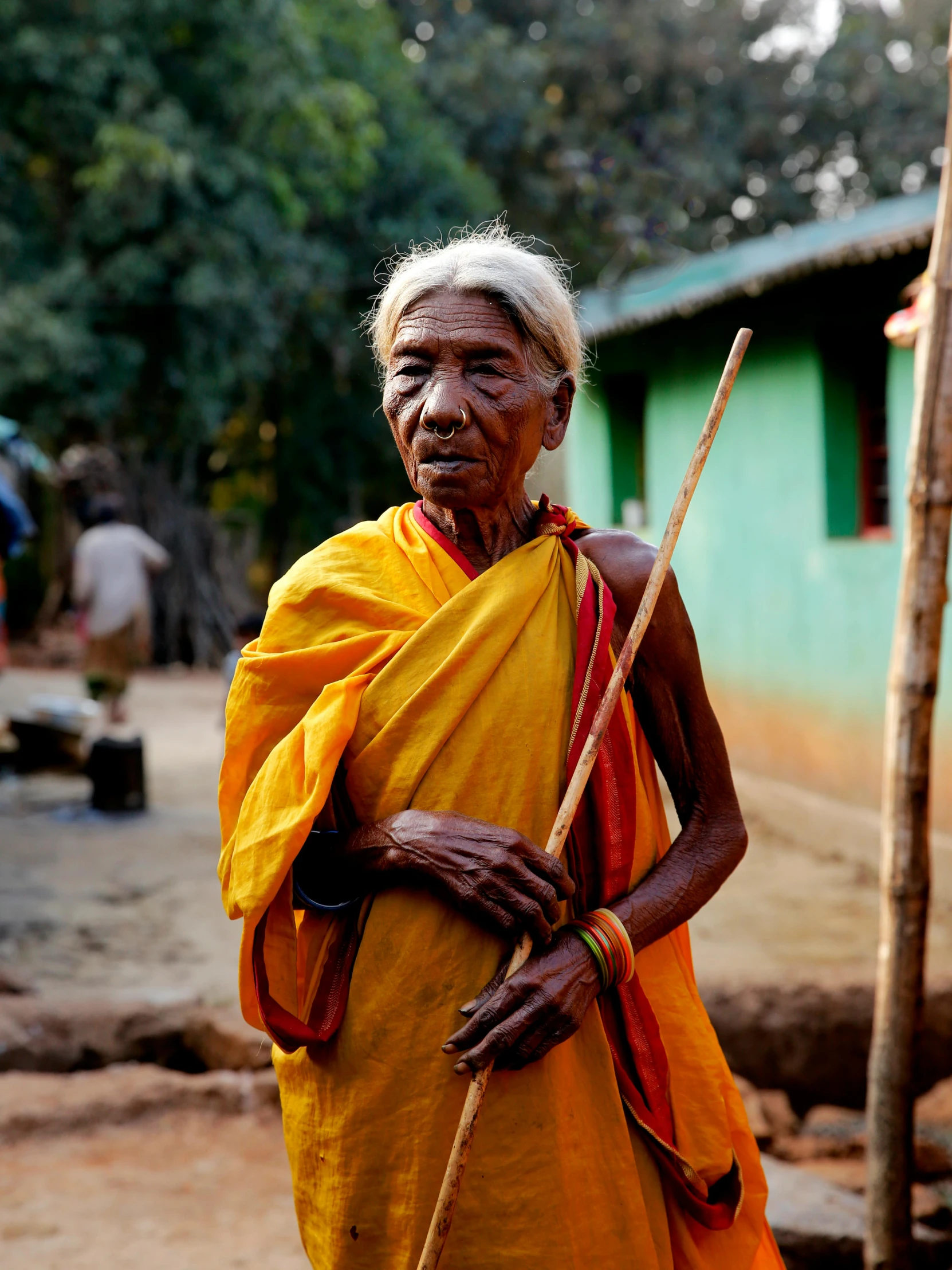 a person is dressed in a yellow dress and holding a stick