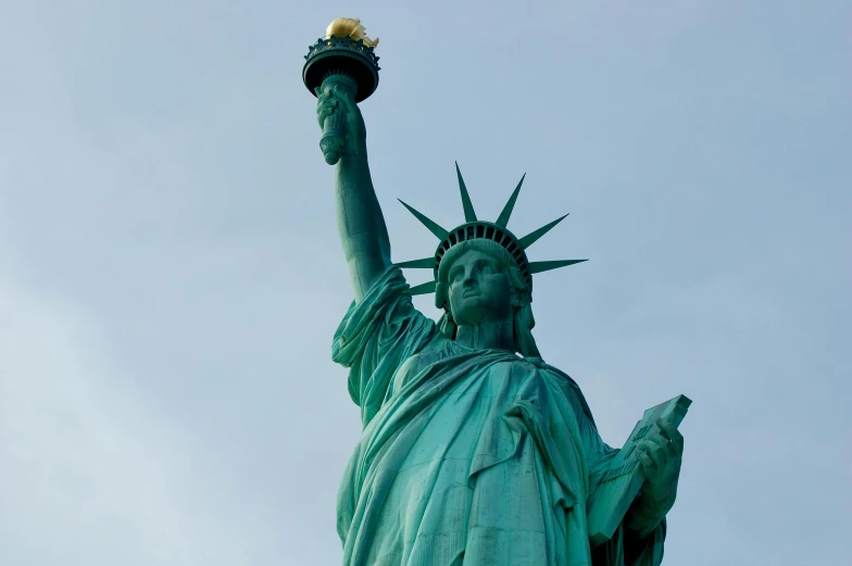 the top portion of the statue of liberty with its torch in its hands