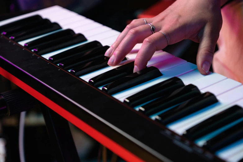 person's hand on the keys of a music keyboard