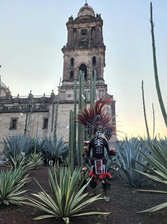 a costumed soldier sitting near cactuses in front of a building