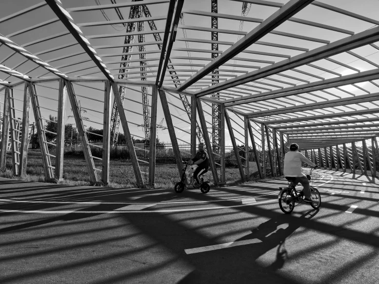 two people riding their bicycles down a bike path