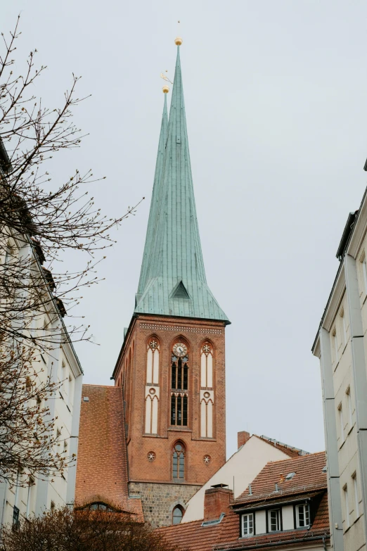 an old cathedral with blue roof is next to small buildings