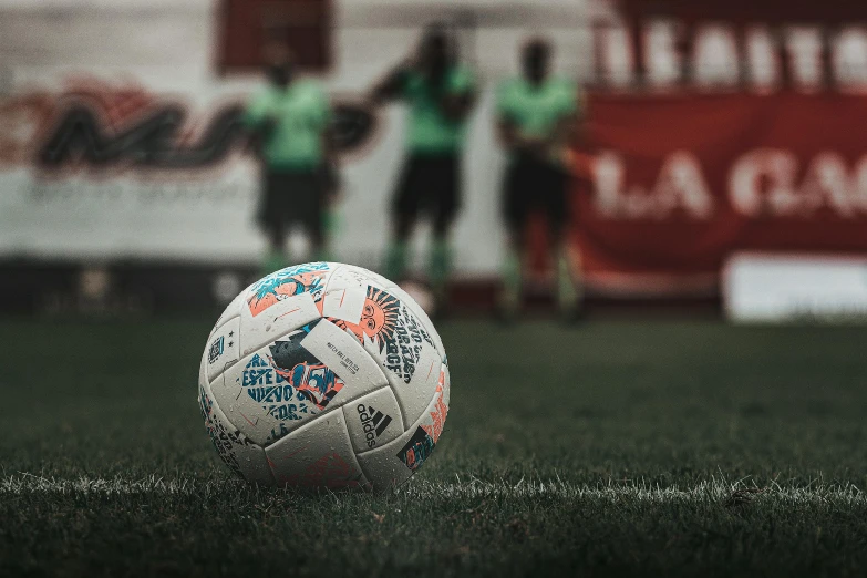 an official soccer ball on the field with the scoreboard in the background