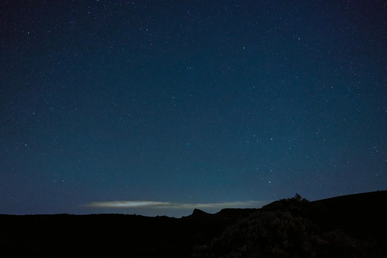 a distant view of the night sky, with small stars above the horizon