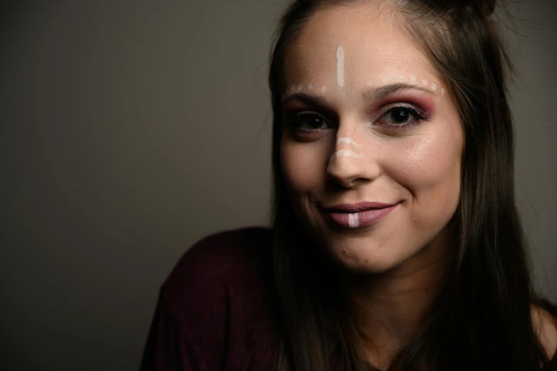 a beautiful woman posing for a po wearing makeup