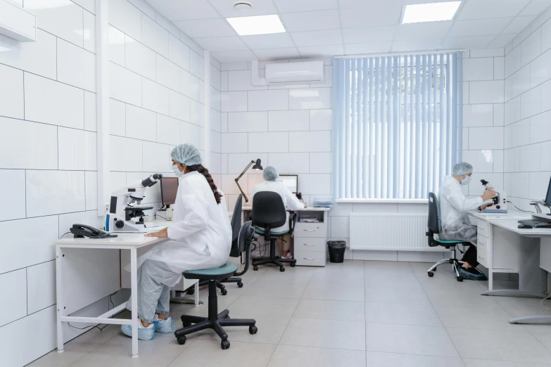 a group of people with lab coats sitting around desks