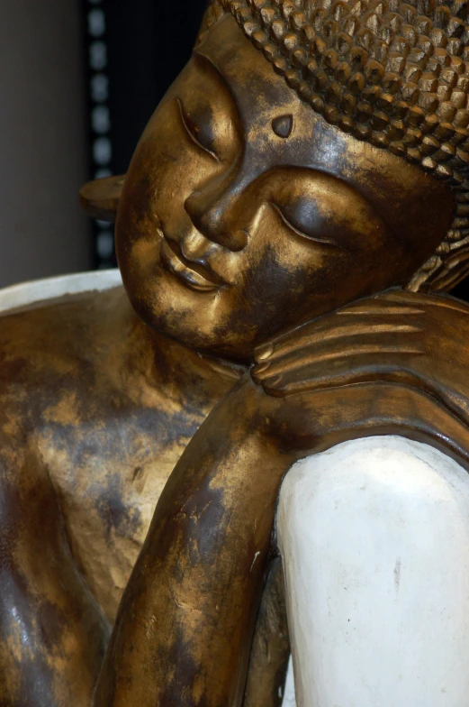 a bronze statue with a book and white blanket