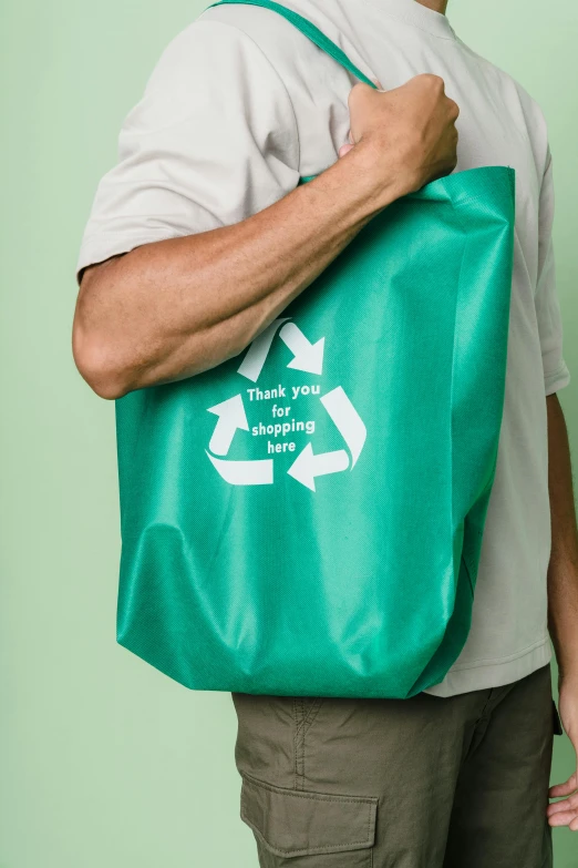 a man carrying a green bag with an i - love - you message on it